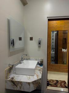 a bathroom with a white sink and a mirror at Go Glam Hotels Murree in Murree +31 photos