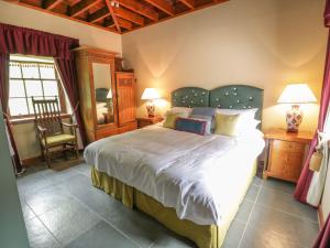 a bedroom with a large bed and a chair at Duck Pond- Uk7232 in Kirkmichael