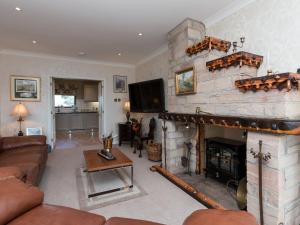 a living room with a fireplace and a tv at Hillend Farm House in Dalry