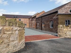 a brick building with a sign in front of it at Y Stabl - Uk12742 in Acrefair
