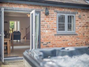 an open door to a brick house with a patio at Y Stabl - Uk12742 in Acrefair