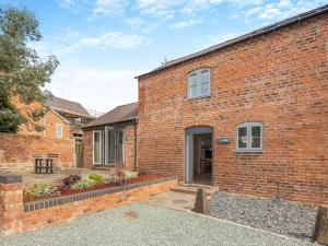 a brick building with a door and a courtyard at Y Stabl - Uk12742 in Acrefair