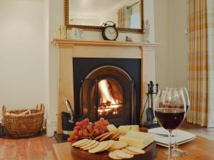 a table with a plate of cheese and a glass of wine at The Coach House in Keswick