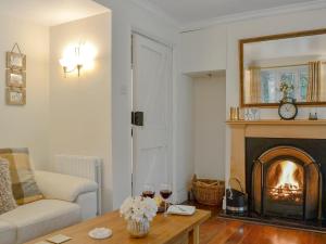 a living room with a fireplace and a couch at The Coach House in Keswick