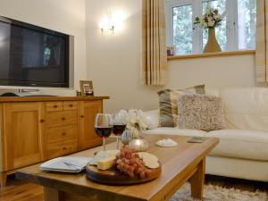 a living room with a table with wine glasses and cheese at The Coach House in Keswick