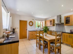 a kitchen with a wooden table and a dining room at Beech Barns - Czu in Neatishead