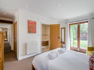 a bedroom with a white bed with towels on it at Beech Barns - Czu in Neatishead +18 photos