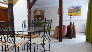 a dining room with a glass table and chairs at Le logis de Presle in Avallon