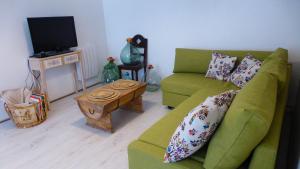 a living room with a green couch and a table at Le logis de Presle in Avallon