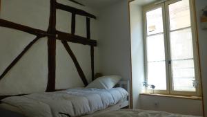 a bedroom with two beds and a window at Le logis de Presle in Avallon