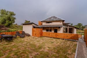 a house with a fence and a table and chairs at The Attic Library by AVVAs Stays in Bīr