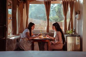 two women sitting at a table in a restaurant at The Attic Library by AVVAs Stays in Bīr