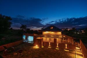 a house with lights on it at night at The Attic Library by AVVAs Stays in Bīr +9 photos