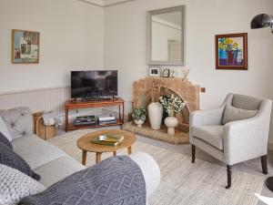 a living room with a couch and a tv at Green Acres in Llangollen