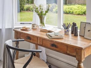 a wooden desk in front of a window with a book at Green Acres in Llangollen