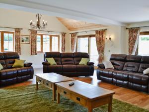 a living room with leather couches and a coffee table at The Stable - Om4 in Mydroilin