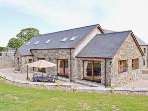 a stone house with a black roof and windows at The Stable - Om4 in Mydroilin +7 photos