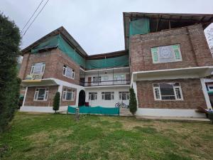a large brick house with a green roof at Payer Resort in Pharkian