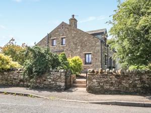 an old stone house with a stone wall at Garth End in Appleby