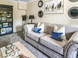 a living room with a gray couch and blue pillows at Garth End in Appleby