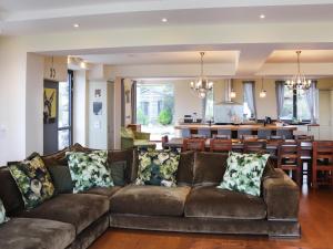 a living room with a brown couch and a kitchen at Snowdon Summit View in Llanllyfni