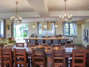 a kitchen and dining room with a large wooden table and chairs at Snowdon Summit View in Llanllyfni