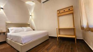 a small bedroom with a white bed and a table at Casa Antonio Mazunte in Mazunte