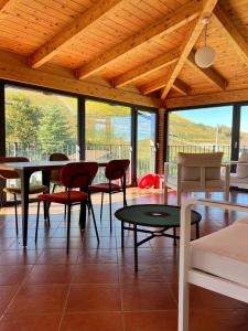 a living room with a table and chairs and windows at Cascina 1909 in Priocca