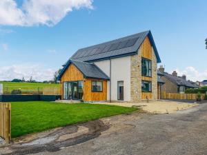 a house with a black roof with a yard at Hillside House in Berwick-Upon-Tweed