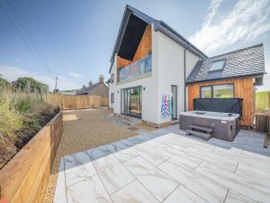 a house with a patio with a grill at Hillside House in Berwick-Upon-Tweed