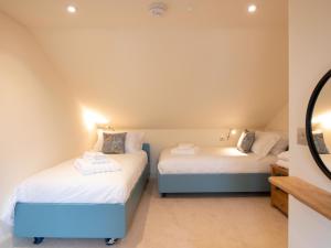 a bedroom with two beds and a mirror at Tree House - Uk7556 in Inverness