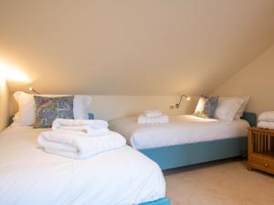 two beds with towels on them in a room at Tree House - Uk7556 in Inverness