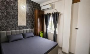 a small bedroom with a bed and a window at Residence Inn in Patna