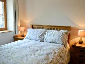 a bedroom with a bed with two lamps on tables at The Mill - Om3 in Mydroilin +10 photos