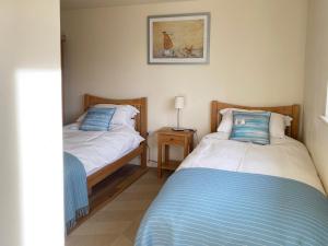 a bedroom with two beds and a night stand at The Stables in Occold +9 photos