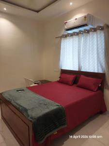 a bedroom with a bed with red sheets and a window at Vishal Lodge in Yermala