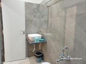 a bathroom with a sink and a mirror at Vishal Lodge in Yermala +2 photos