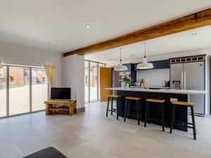 a kitchen with a bar with stools and a tv at The Hayloft - Uk34565 in Whitchurch +16 photos