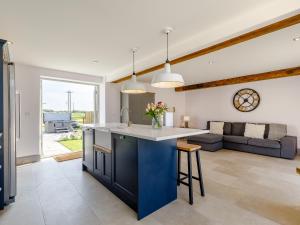 a kitchen and living room with a blue island at The Hayloft - Uk34565 in Whitchurch