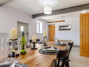 a dining room with a wooden table with wine glasses at The Hayloft - Uk34565 in Whitchurch