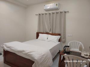 a bedroom with a bed with a white comforter at Vishal Lodge in Yermala