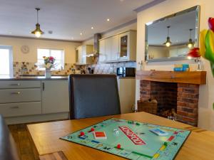 a kitchen and dining room with a table and a fireplace at Sycamore Cottage-Uk2785 in Penmaen-mawr