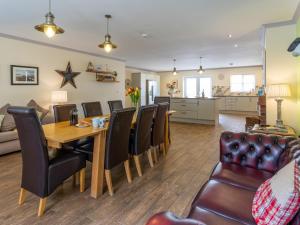 a dining room and living room with a table and chairs at Sycamore Cottage-Uk2785 in Penmaen-mawr