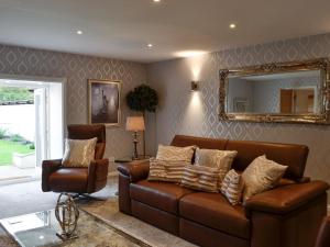 a living room with a couch and a mirror at Apple Tree House in Dalry