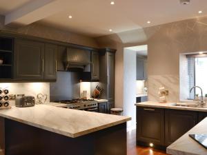 a kitchen with black cabinets and a counter top at Apple Tree House in Dalry