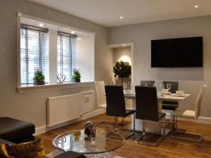 a living room with a table and chairs and a television at Apple Tree House in Dalry