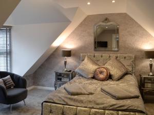 a bedroom with a bed with a mirror and a chair at Apple Tree House in Dalry +11 photos