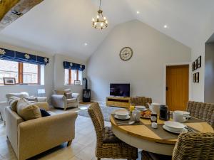 a living room with a table and chairs at The Wheat Store - Uk32649 in Elston