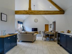 a kitchen and living room with blue cabinets and a table at The Wheat Store - Uk32649 in Elston