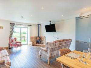a living room with a table and chairs and a television at The Old Stables - Uk37000 in Ridlington